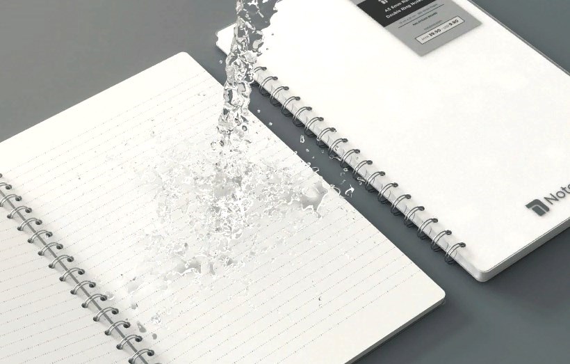 A photo of a waterproof stone paper notebook with water splashing on it.